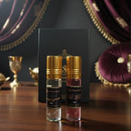 Two perfume bottles with gold caps on a wooden surface with decorative background