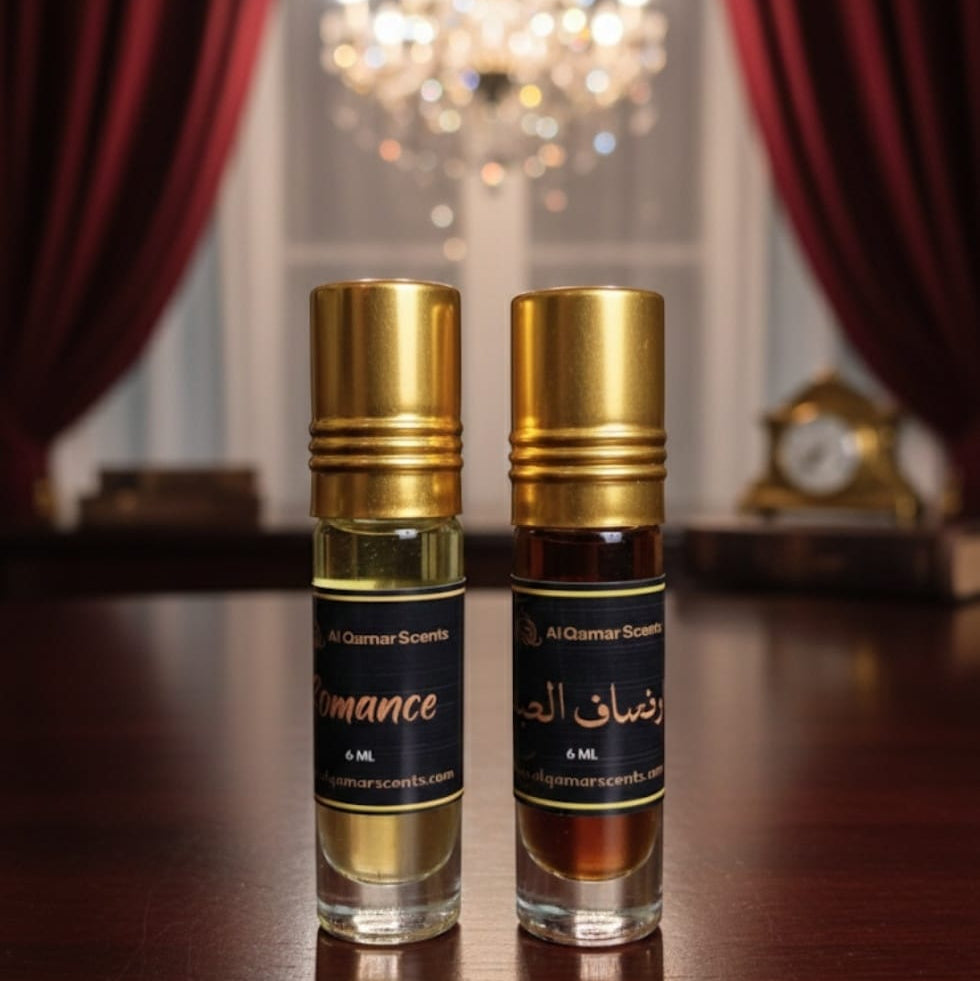 Two perfume bottles on a wooden surface with a chandelier in the background