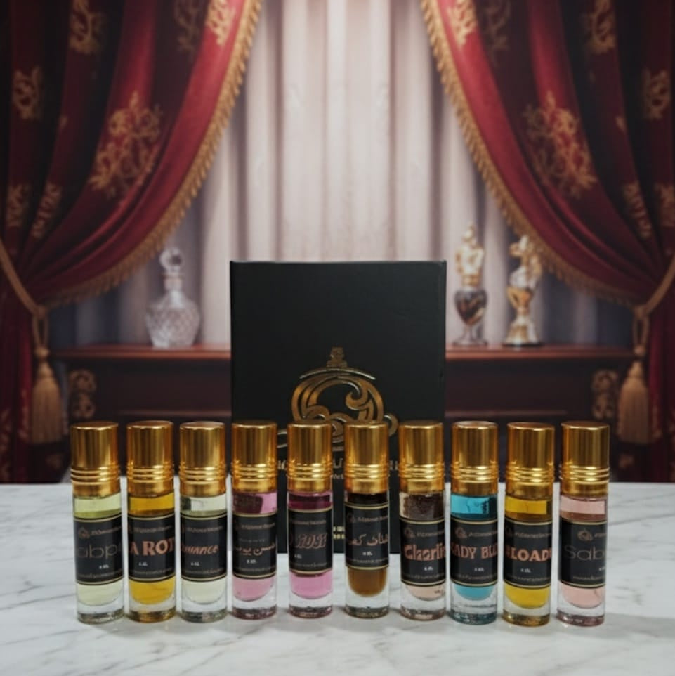 Set of perfume bottles with gold caps on a marble surface, with decorative curtains in the background.